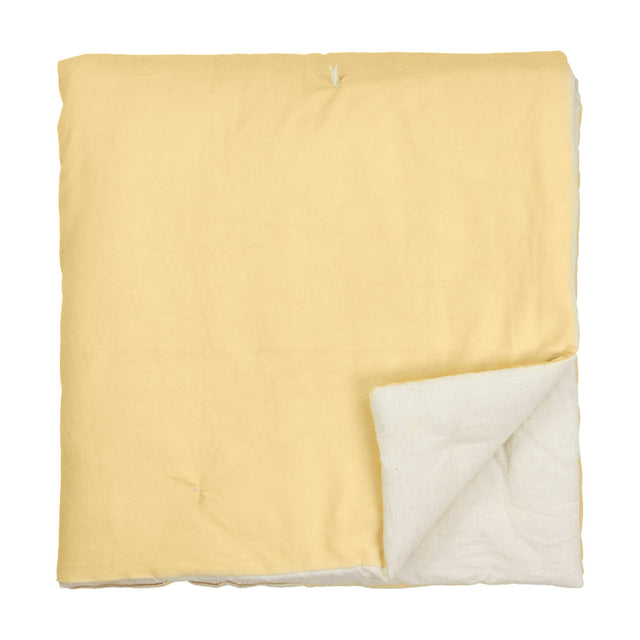 Edie Linen Cotton Bedspread in butter yellow, quilted velvet folded to reveal a pale natural linen-look reverse, shown on a plain white background.