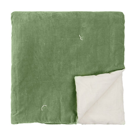 Edie Linen Cotton Bedspread in green, quilted velvet face folded to reveal a pale linen-look reverse, shown on a plain white background.