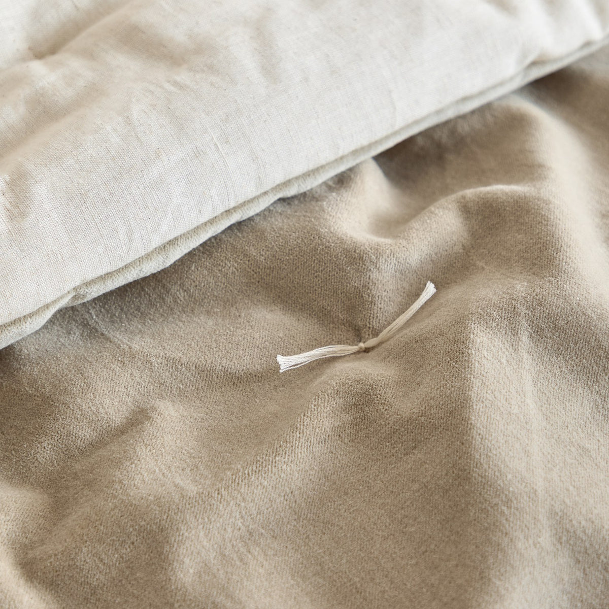 Close-up of the Edie quilted cotton velvet bedspread in natural, showing the tufted stitch detail and contrast between the soft velvet face and linen-look cotton reverse.