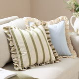 Effie Plain Cotton Cushion in sky blue with a gathered vintage cream ruffle trim, shown on a beige sofa alongside a green and cream striped ruffled cushion.