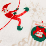 Close-up of the Elfie printed polyester throw in cream, showing a skiing elf in red and green with a wreath and snowflake motif on the fleece fabric.