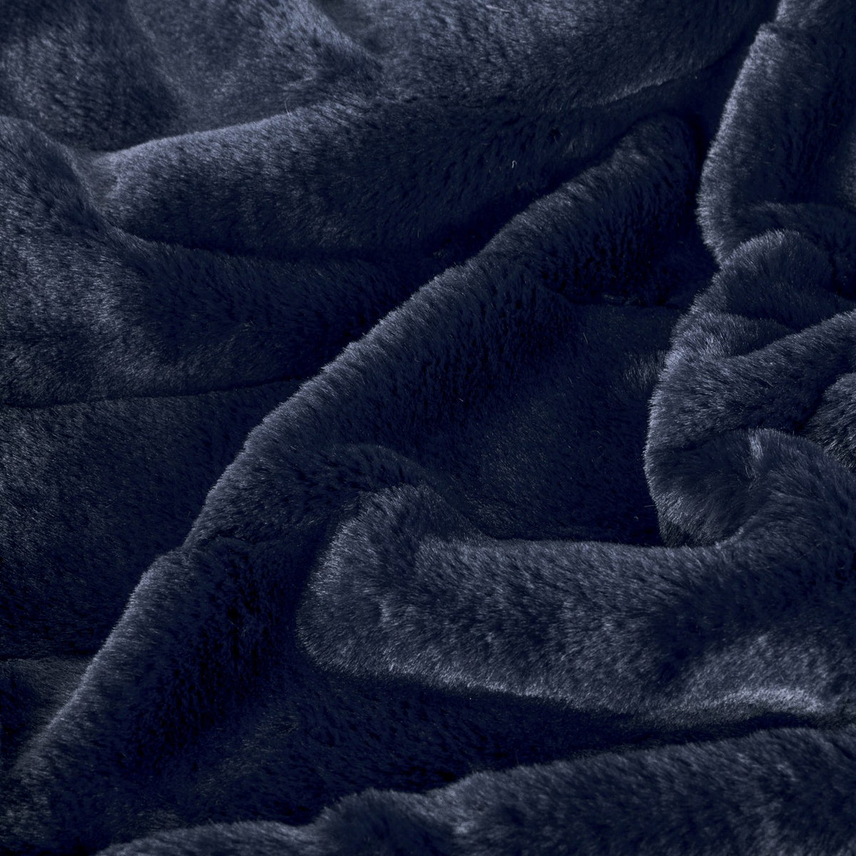 Empress Velvet Faux Fur Throw in navy, close-up of the plush, softly draped pile showing its deep blue tone and dense faux fur texture.