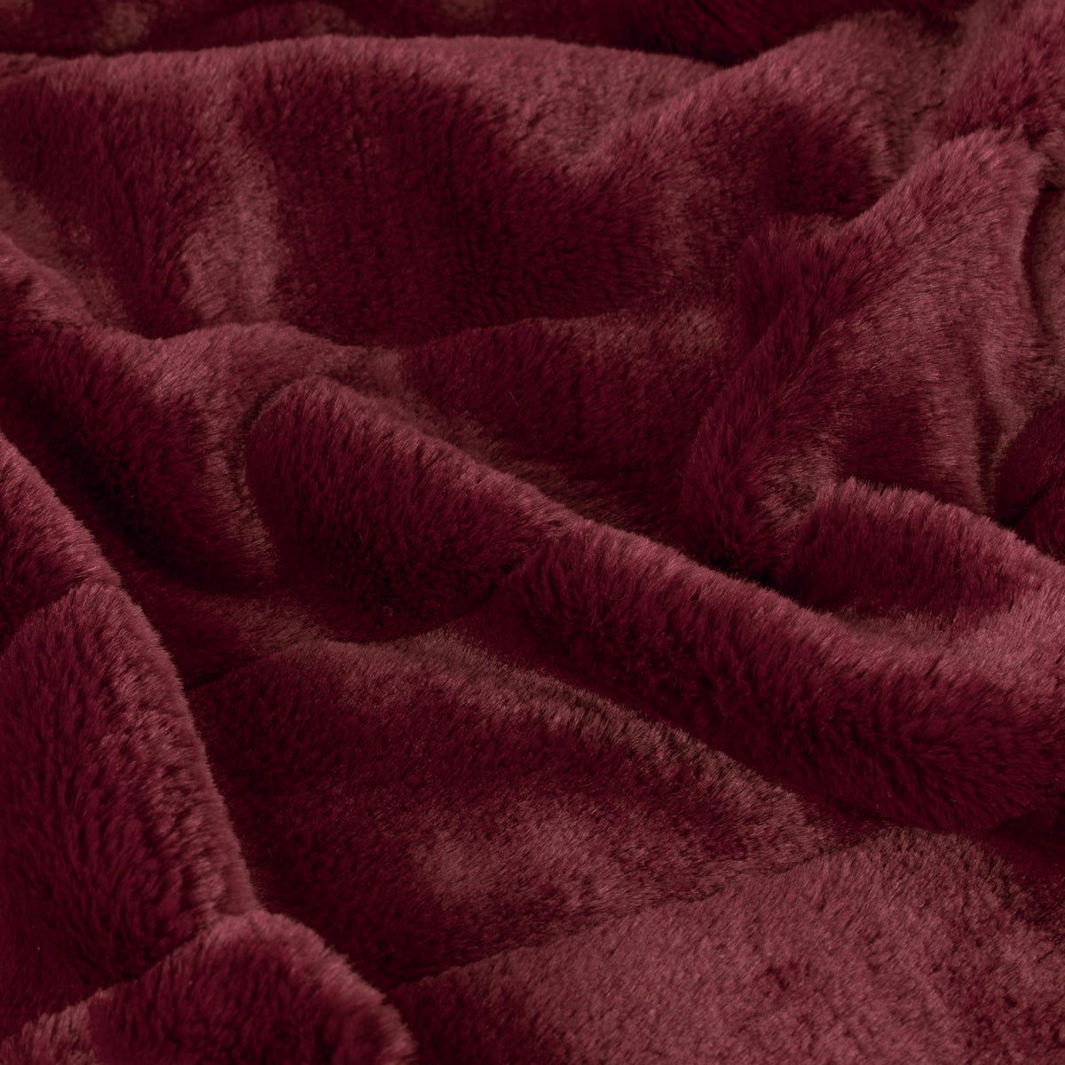 Close-up of the Empress Velvet Faux Fur Throw in ruby red, showing its plush, long-pile texture folded into soft draped layers.