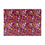 Enchanted Printed Polyester Throw in pink on a plum ground, featuring gold moons, stars, planets, cherries and mystical motifs, shown flat on a white background.