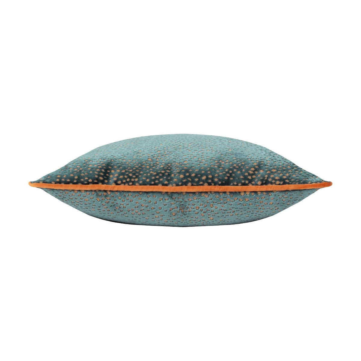 Side view of the Estelle Reversible Velvet Cushion in teal with amber-rust spotted texture and contrast orange piping along the edge, shown on a white background.