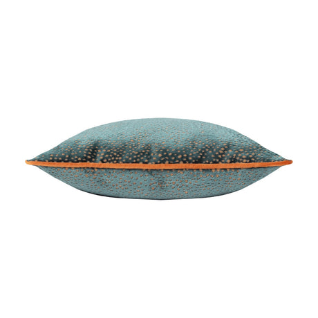 Side view of the Estelle Reversible Velvet Cushion in teal with amber-rust spotted texture and contrast orange piping along the edge, shown on a white background.