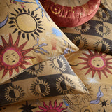 Ethereal Reversible Abstract Duvet Cover Set in Gold Rust, shown with matching pillowcases featuring sun-face and moon prints, reverse side in gold and grey checkerboard sun pattern.