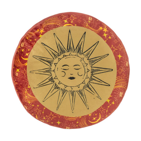 Round velvet cushion from the Ethereal range in gold and rust, featuring an embroidered sun face on a gold panel edged by a rust border with stars, moons and comets, shown on a white background.