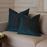 Two Evoke Geometric Velvet Cushions in navy with gold-threaded chevron patterns, styled on a beige sofa in a living room setting.