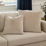 Two Evoke Geometric Velvet Cushions in pale oyster with chevron pattern and metallic thread detail, styled on a beige sofa in a living room.