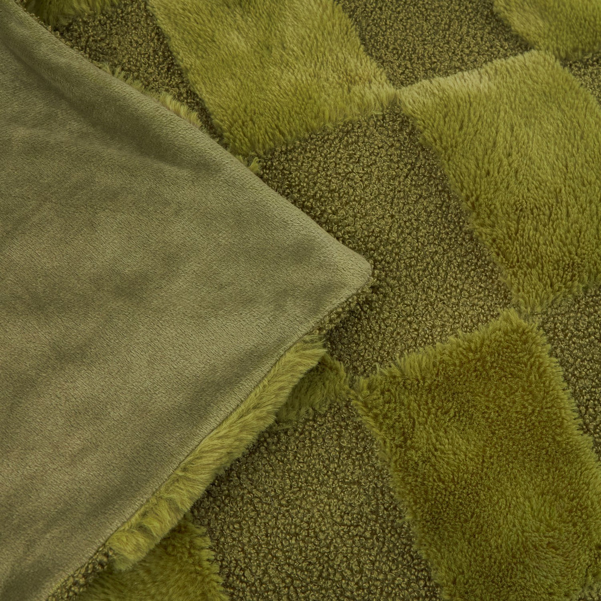 Close-up of the Fur Boucle Check Velvet Faux Fur Throw in olive, showing checkerboard faux fur and boucle squares beside the folded smooth velvet reverse.