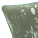 Close-up of the Fearne reversible velvet cushion in sage green, showing a hand-drawn white botanical print of ferns and grasses with green piped edging.