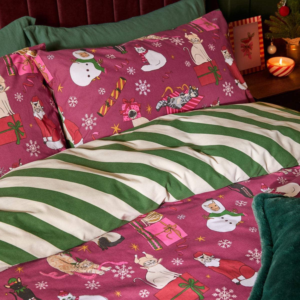 Feline Festive Cotton Striped Duvet Cover Set in Purrgundy, shown on a bed with berry-red cat-print pillowcases and a reversible green and cream striped duvet.