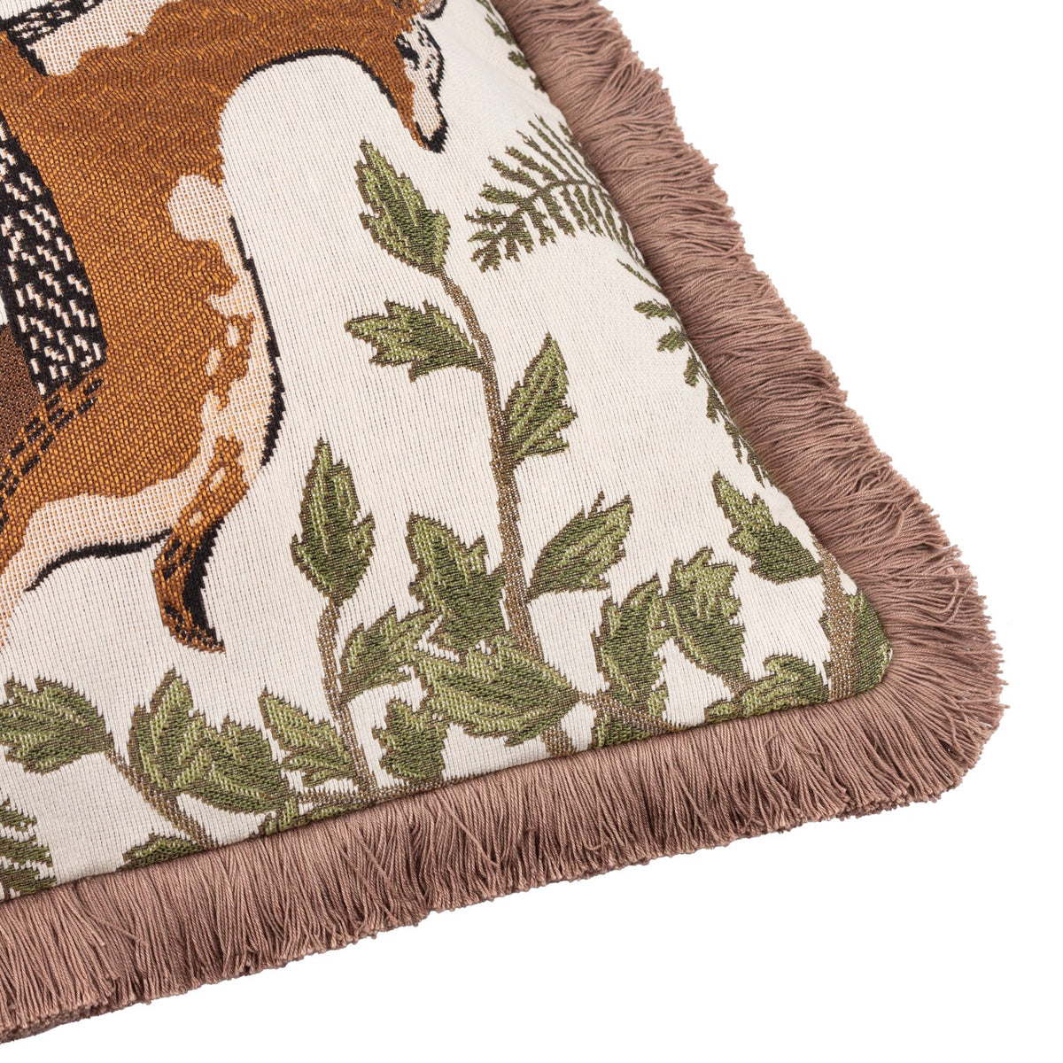 Corner detail of the Fable Fox and Deer Woodland Cotton Cushion, showing woven fox and foliage design on cream cotton with dusky-pink fringe trim.