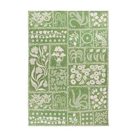 Forage Garden Floral Polyester Rug in sage green, patchwork grid of cream floral, fern, mushroom and peacock motifs on a flatweave base, shown on a plain white background.