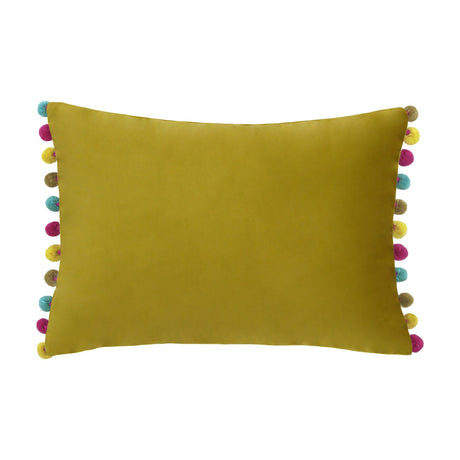 Fiesta Velvet Bamboo Cushion, a rectangular gold-green velvet cushion with pink, teal, yellow and taupe pompom trim along its shorter edges, shown on a plain white background.
