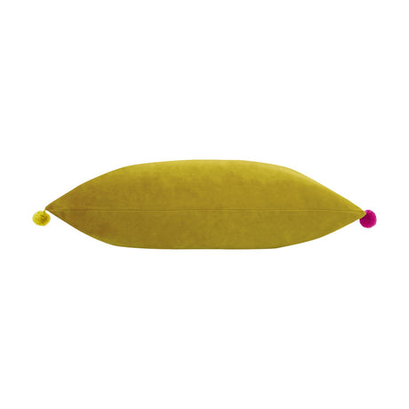 Fiesta Velvet Bamboo Cushion, a long rectangular bolster-style cushion in gold-green velvet with a yellow pompom on one end and a pink pompom on the other, shown on a plain white background.