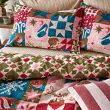 Fika Cotton Geometric Duvet Cover Set in Multi, with matching pillowcases in a Christmas patchwork of stars, swans, snowflakes and holly, reverse in a geometric diamond-star print.