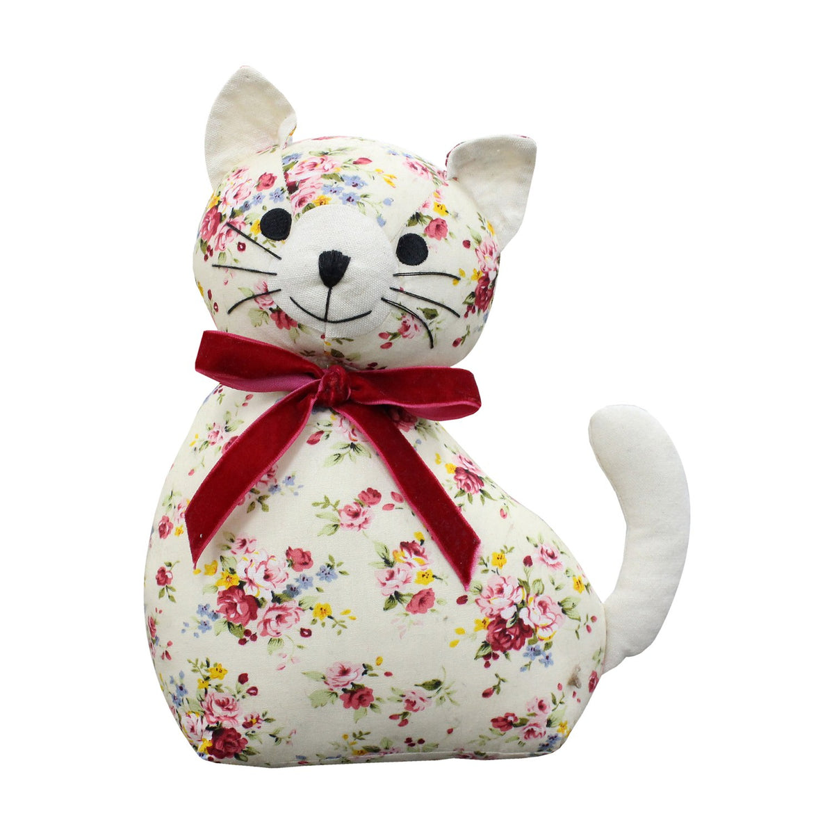 Cat-shaped door stop in floral print fabric with cream ears and tail, a red velvet bow at the neck, and stitched facial features, on a white background.