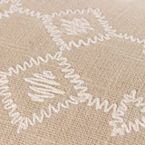 Close-up of the Folis Geometric Cotton Cushion in stone, showing raised cream embroidered diamond and cross motifs on a slubby beige cotton base.