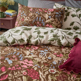 Forest Bloom Reversible Floral Duvet Cover Set in Chocolate, shown on a bed with floral wildflower and mushroom print pillowcases beside a cream oak-leaf reverse side.