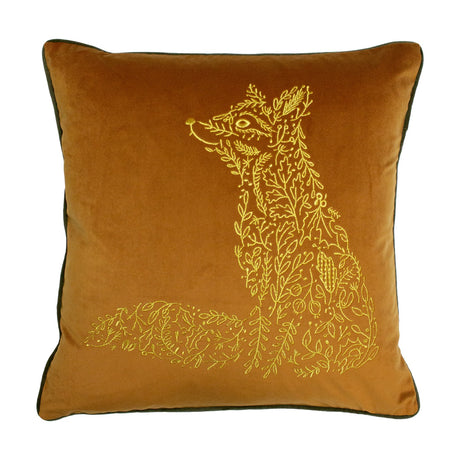 Square rust velvet cushion with gold embroidered fox made of leaves and sprigs, seated in profile, edged with olive-grey piping, on a white background.