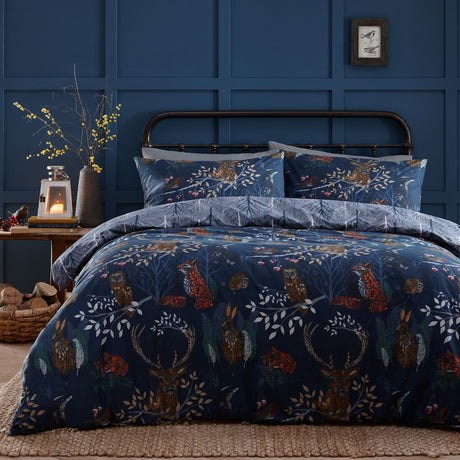 Navy Forest Fauna Woodland Animal Duvet Cover Set with matching pillowcases featuring stag, fox, owl and hare designs, shown on a bed in a dark blue panelled bedroom.