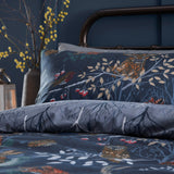 Forest Fauna Woodland Animal Duvet Cover Set in navy, shown on a bed with a printed forest scene of birds, branches and berries, paired with a matching pillowcase.