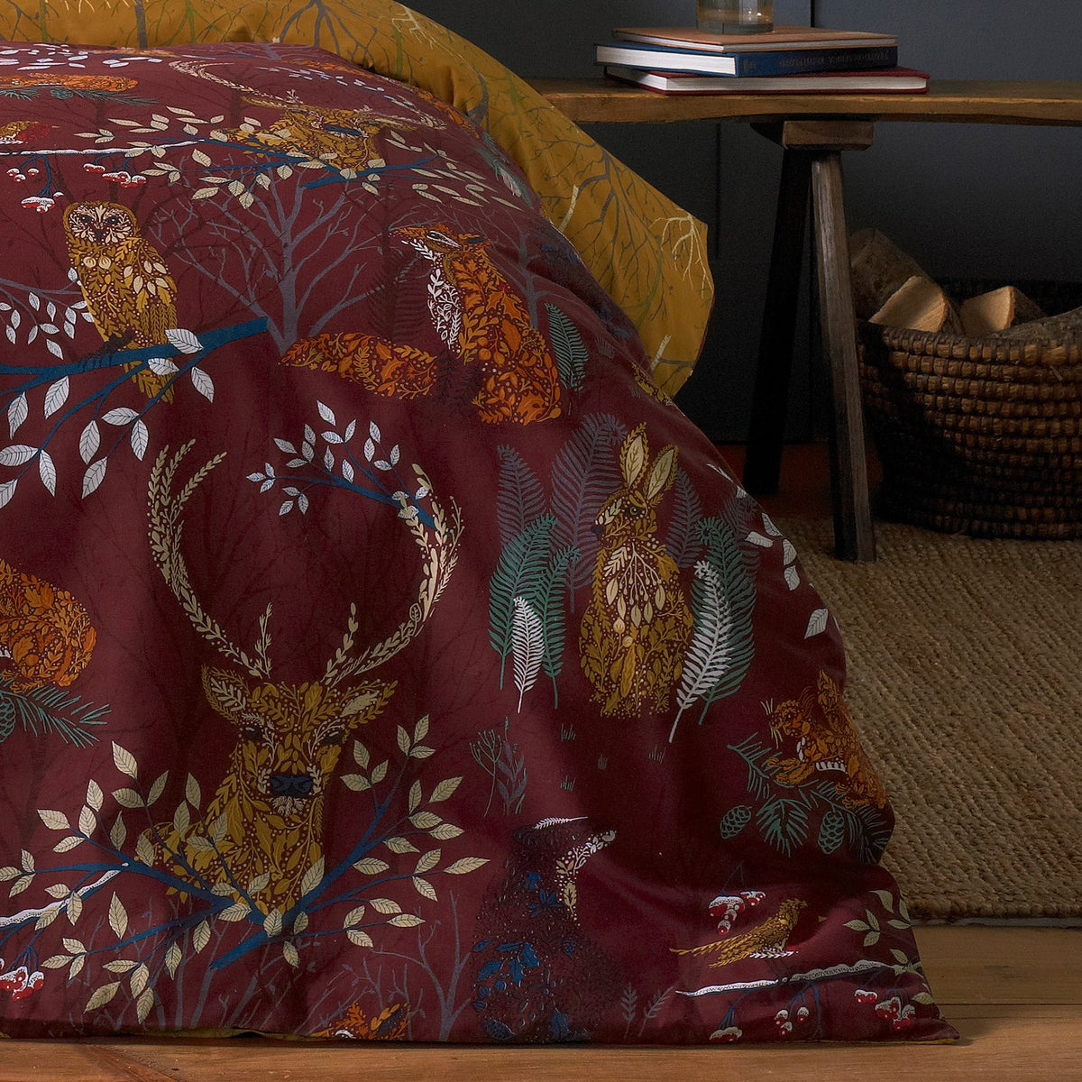 Forest Fauna Woodland Animal Duvet Cover Set in rust, shown on a bed with a mustard reverse, featuring stag, owl, fox and hare motifs in a bedroom setting.