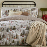 Forest Festivities Cotton Spotted Duvet Cover Set in natural, styled on a bed with matching pillowcases, cushions and a cream faux-fur throw in a bedroom setting.