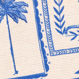 Close-up of the Frieze Abstract Polyester Rug in blue, showing a palm tree and framed border panels with leaf and wave motifs printed in cobalt blue on cream flatweave.