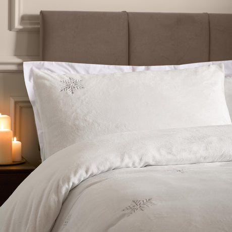 White flannel fleece duvet cover set with embroidered silver-grey snowflake motifs, shown on a bed with matching pillowcase against a taupe headboard.