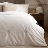 White flannel fleece duvet cover with embroidered silver-grey snowflakes, shown styled on a bed with matching pillowcase in a bedroom setting.