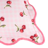 Close-up of the Fruits Gingham Polyester Cushion in pink, showing red cherry print on pink gingham fabric with a scalloped edge and deeper pink piped trim.