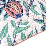 Fruits Piped Polyester Cushion in Coral/Lemon, close-up of pomegranate and citrus print with green leaves on pale ground, coral pink piped edge trim.