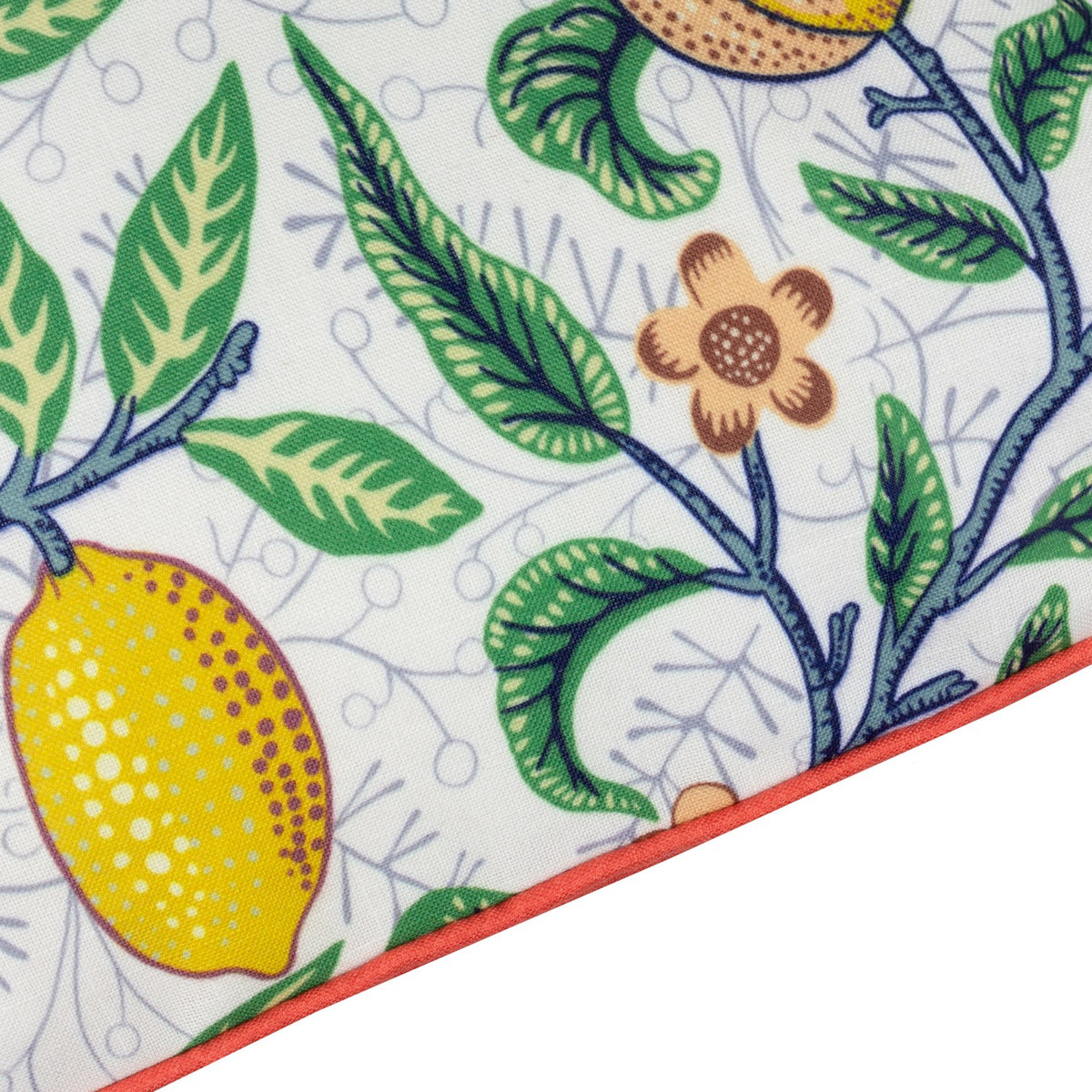 Close-up of Fruits Piped Polyester Cushion corner, showing lemons, pomegranate blooms and green leaves on a pale ground with tomato-red piped edge trim.