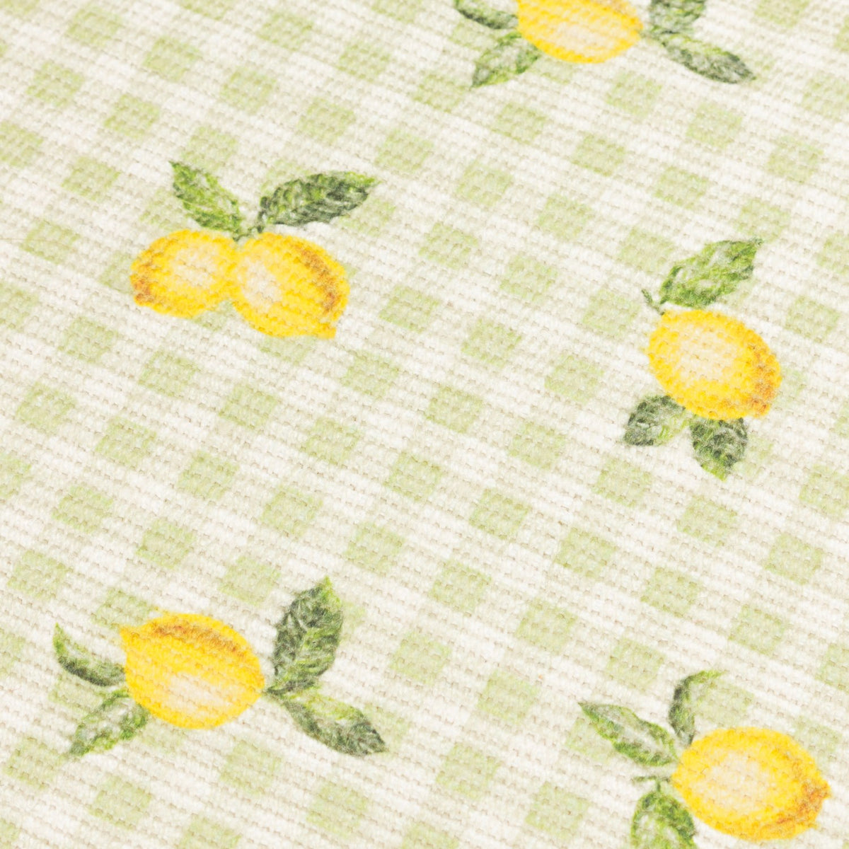 Fruits Gingham Polyester Placemat in sage, close-up of woven fabric with hand-painted lemons and leaves over a green and cream check pattern.