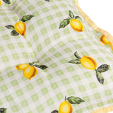 Close-up of a Fruits Gingham polyester placemat in sage, showing a hand-painted lemon and leaf print over a green and cream check with a yellow trim edge.