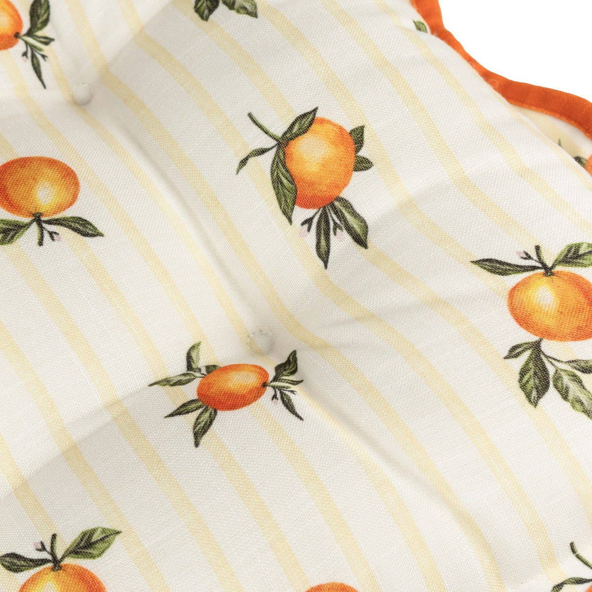 Close-up of the Fruits Striped Polyester Seat Pad in yellow, showing a tufted, button-tied surface printed with orange fruit motifs on yellow stripes, edged with a scalloped rust-orange trim.