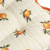 Close-up of the Fruits Striped Polyester Seat Pad in yellow, showing a tufted, button-tied surface printed with orange fruit motifs on yellow stripes, edged with a scalloped rust-orange trim.