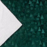 Festive Time Sherpa Woodland Polyester Throw in emerald green, showing the fleece front with embossed tree and snowflake pattern folded back to reveal the white sherpa reverse.