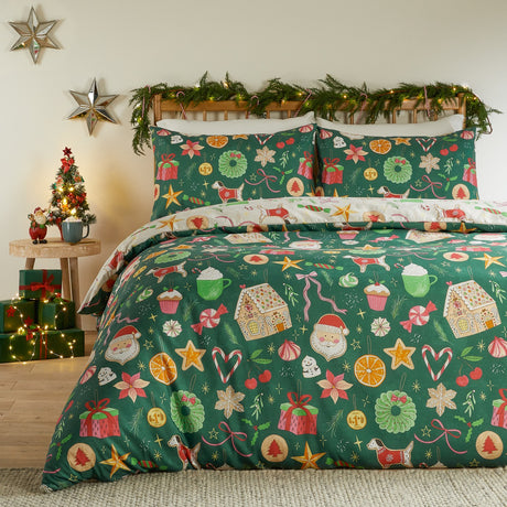 Emerald green reversible duvet cover set with festive treats print—gingerbread houses, Santas, candy canes and wreaths—shown styled on a bed in a Christmas-decorated bedroom.