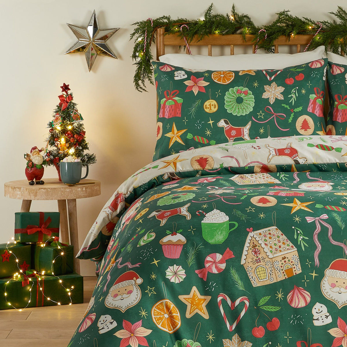Emerald green Festive Treats Printed Reversible Duvet Cover Set with pillowcases on a bed, patterned with gingerbread houses, Santa faces, candy canes, stars and festive motifs in a bedroom setting.