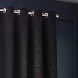 Galaxy Chenille fully lined eyelet curtains in black with gold flecks, shown close-up on brushed metal grommets and a pole against a dark wall.