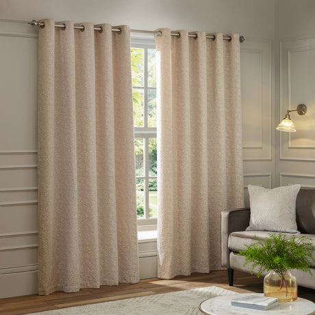 Galaxy Chenille fully lined eyelet curtains in blush, shown hanging by a window in a living room, with a flecked cream and pink textured fabric and brushed metal eyelets.