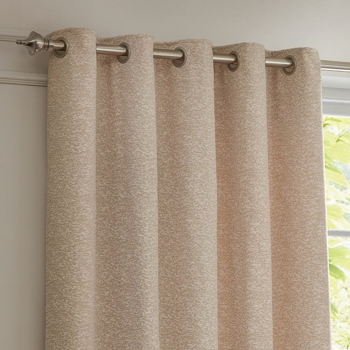 Galaxy Chenille Fully Lined Eyelet Curtains in blush, showing textured flecked fabric with brushed metal eyelets on a chrome pole beside a window.