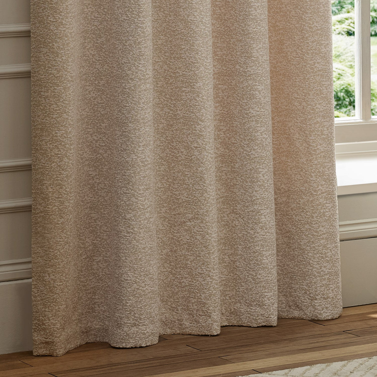 Galaxy fully lined eyelet curtains in blush chenille fabric with a mottled cream and pink texture, hanging in folds beside a window in a living room.