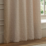 Galaxy fully lined eyelet curtains in blush chenille fabric with a mottled cream and pink texture, hanging in folds beside a window in a living room.