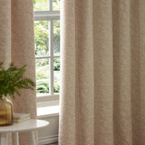 Galaxy Chenille Fully Lined Eyelet Curtains in Blush, showing textured chenille fabric with mottled pink and cream tones, hung beside a window in a living room setting.