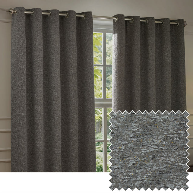Galaxy Chenille fully lined eyelet curtains in charcoal, shown hanging on a metal pole beside a window in a living room, with a textured swatch inset showing flecked grey-black fabric.